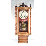 A late 19th century drop-dial wall clock in a walnut and marquetry case with pilaster columns, the