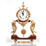 A reproduction mantel clock, the circular dial with Roman and Arabic numerals, the case supported by