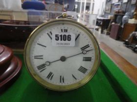 A late 19th century timepiece with an enamelled dial, Roman numerals and in a brass table-top case