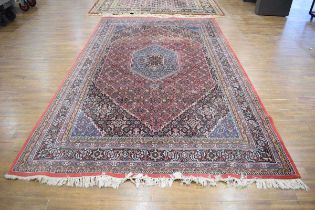 An Iranian carpet, the salmon ground with a pair of graduated medallions and blue detail, 325 x