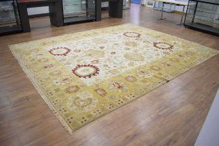 An Indian, Agra, carpet with a cream and gold ground, matching bands and opening flower motifs,