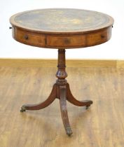 An early-to-mid 20th century walnut and tooled leather drum table, the swivel surface with four