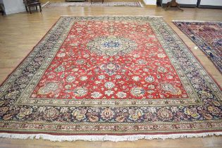 An Iranian carpet, the red ground with a gold medallion within matching borders, 397 x 292 cm Some