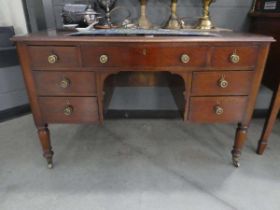 A Victorian mahogany kneehole writing table, the tooled leather surface over an arrangement of seven