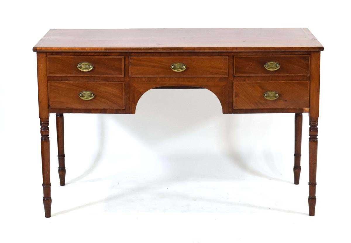 A 19th century mahogany, crossbanded and ebony strung kneehole table with a shaped apron, five