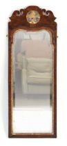 An early 19th century walnut and gilded wall mirror surmounted by a shell pediment, 107 x 40 cm