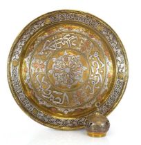 An Islamic Art brass charger with copper and silvered decoration, di. 37 cm, together with a similar
