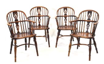 A harlequin set of four 19th century elm and yew windsor armchairs, each with shaped backs and