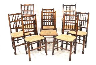 A matched set of eight early 19th century provincial oak dining chairs with spindle backs over