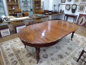 A Victorian mahogany extending dining table, with two fitted leaves, on turned legs with castors,