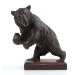 A Black Forest-type carved oak figure modelled as a bear on a plinth, h. 25 cm