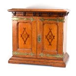 A Victorian and later oak and brass bound two-door table cabinet with marquetry panels, the interior