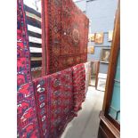 Three Bokhara mats plus a Caucasian rug with floral and geometric pattern (four in total)