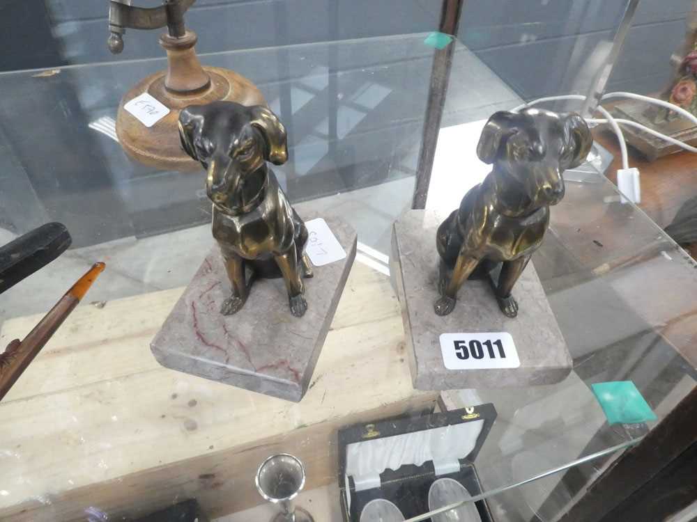 Pair of metal ornamental dogs on marble plinths