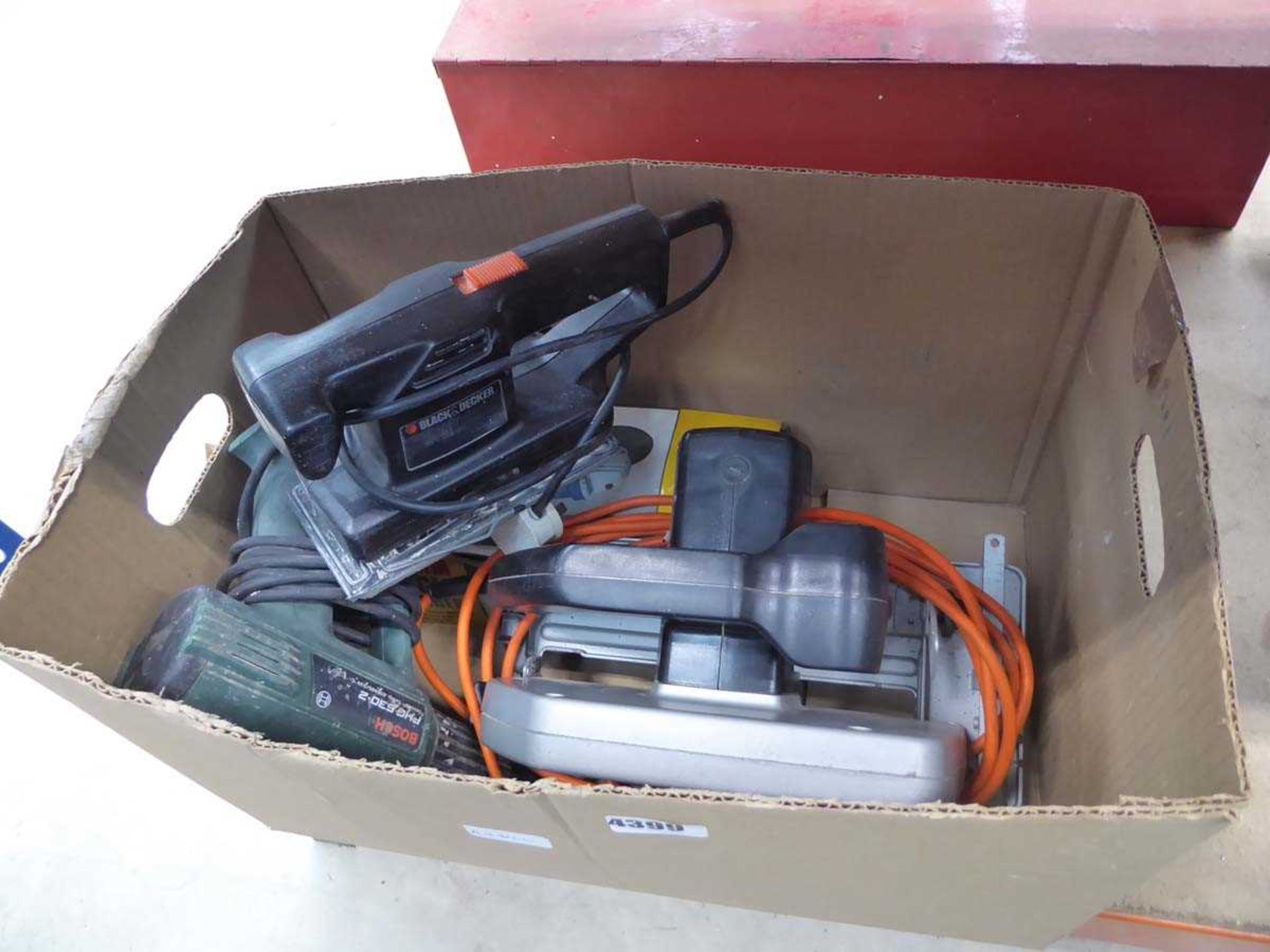 Box containing hot air paint striper, sander, circular saw and angle grinder