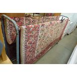 Large pink and red floral patterned woollen carpet