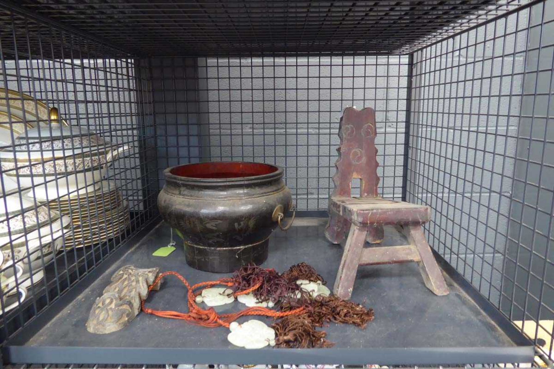 A cage of Oriental object d'art including hardstone pendants, a lacquered water bowl and a primitive