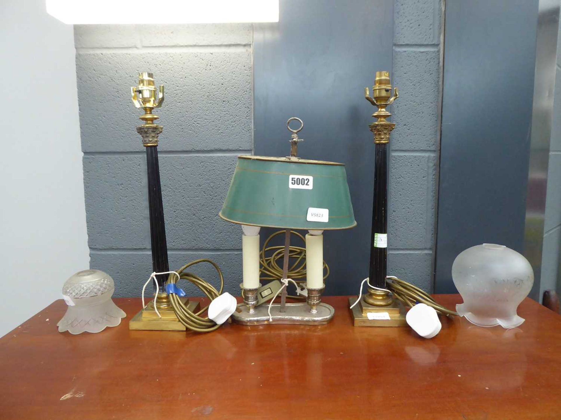 A pair of brass table lamps with Corinthian columns together with a 'twin-candle' desktop lamp and