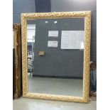 A 20th century rectangular mirror in a moulded floral gilt frame