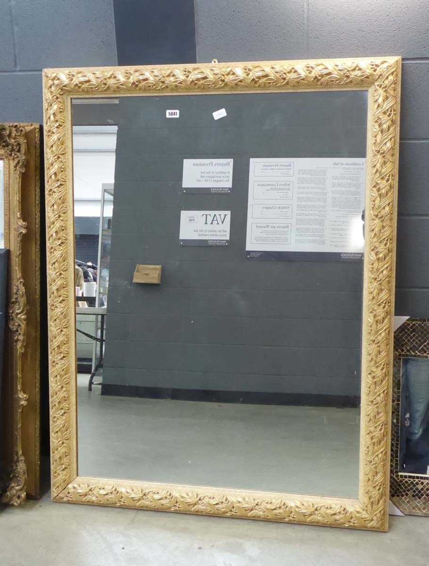 A 20th century rectangular mirror in a moulded floral gilt frame