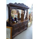 Oak mirrorback sideboard with carved panels and green man decoration
