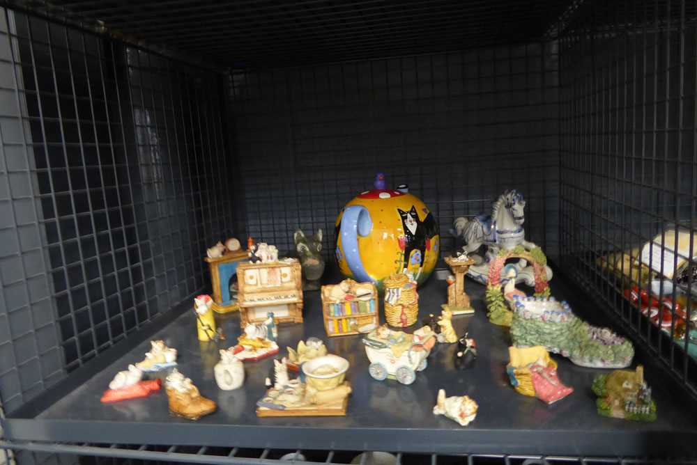 Cage containing miniature cat figures and a teapot