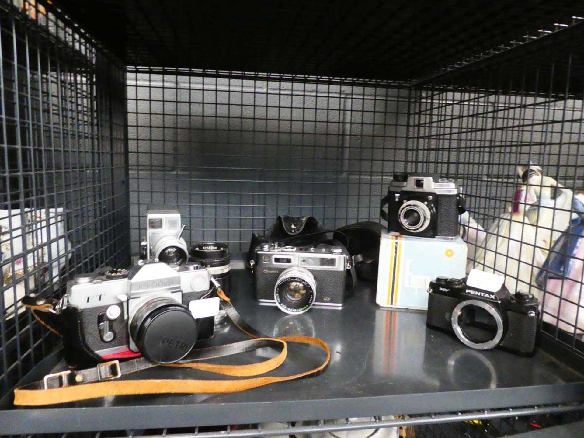 Cage containing a quantity of cameras and lenses