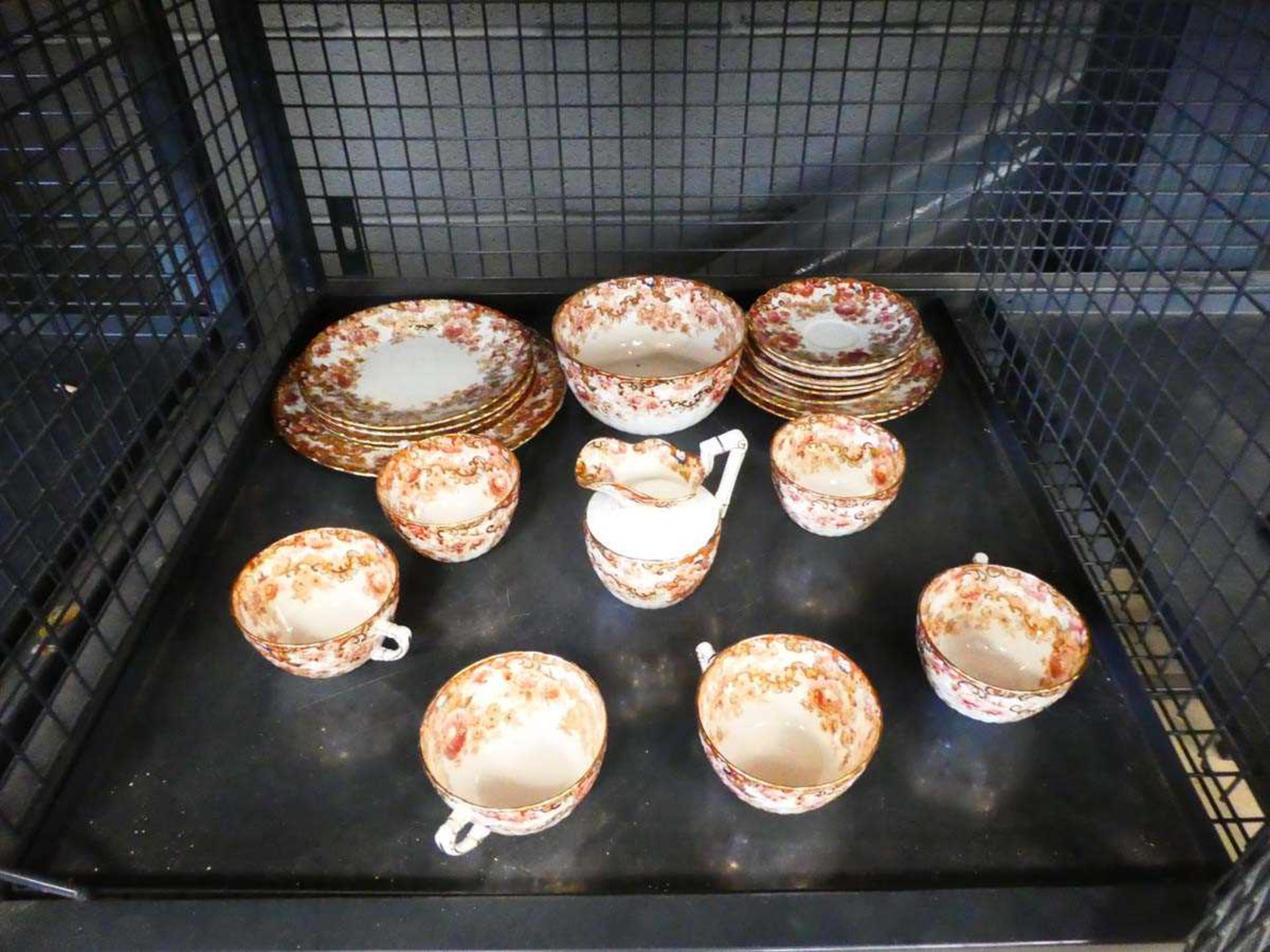 Cage containing floral and gold banded decorated china to include teacups, saucers, plates, bowls