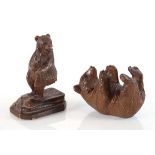 A Black Forest carving modelled as a bear cub on his back, l. 9 cm, together with another similar