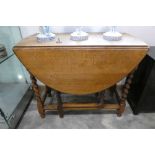 Round dark stained wooden drop leaf gateleg table