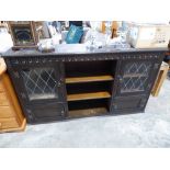 Reproduction dark oak bookcase flanked by leaded glazed doors