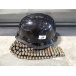 Black military type helmet and a spent cartridge belt