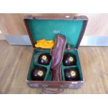 Leather cased set of lawn bowls, including 4 bowls and a pair of brown leather shoes