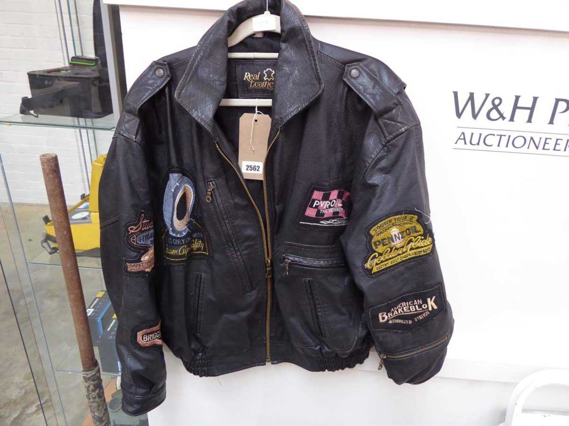 Black leather biker's jacket with mixed badges incl. Briggs & Stratton, Pyroil, etc. (size L)