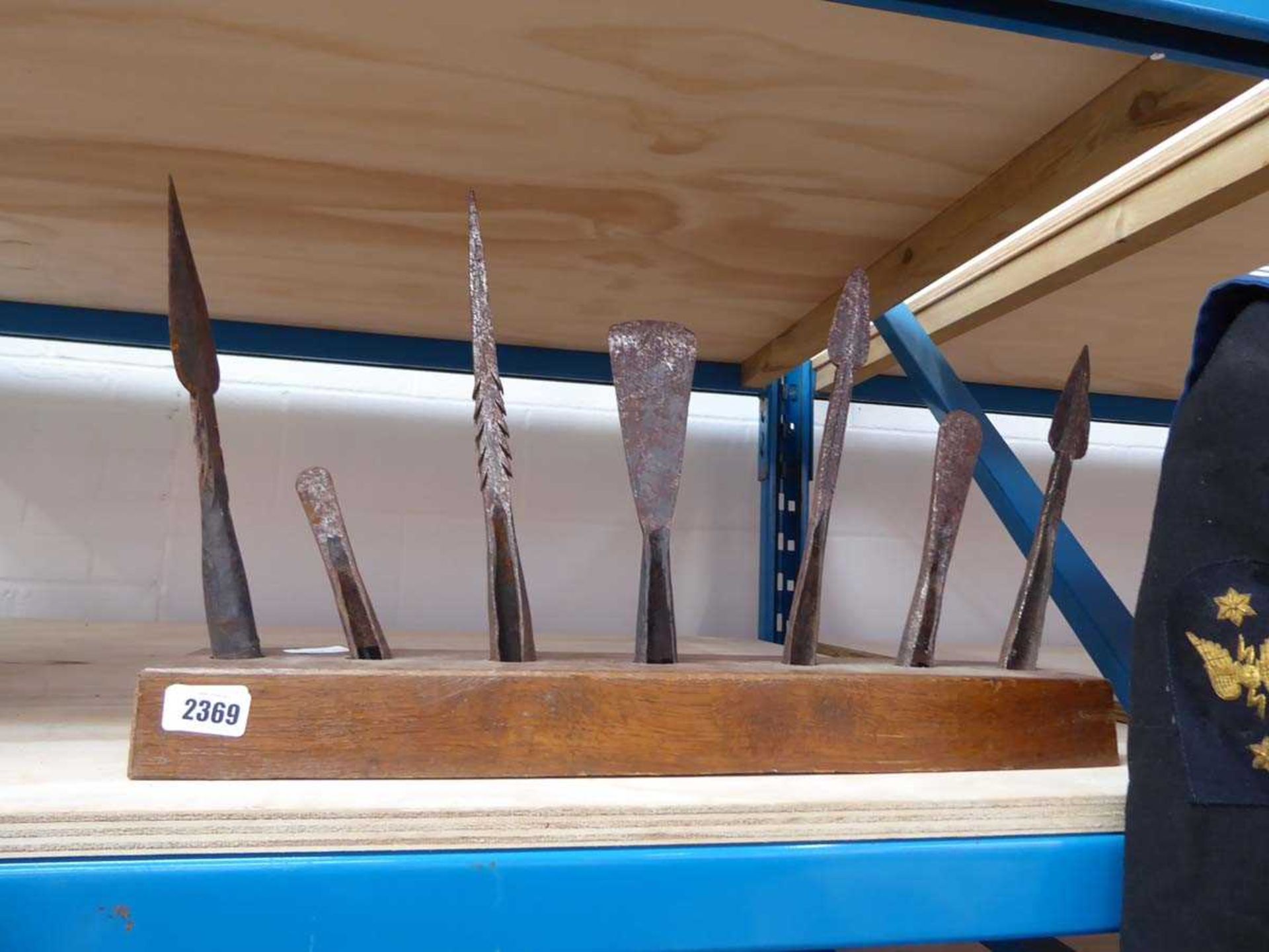 An array of 7x iron hunting spear heads mounted within an oak block