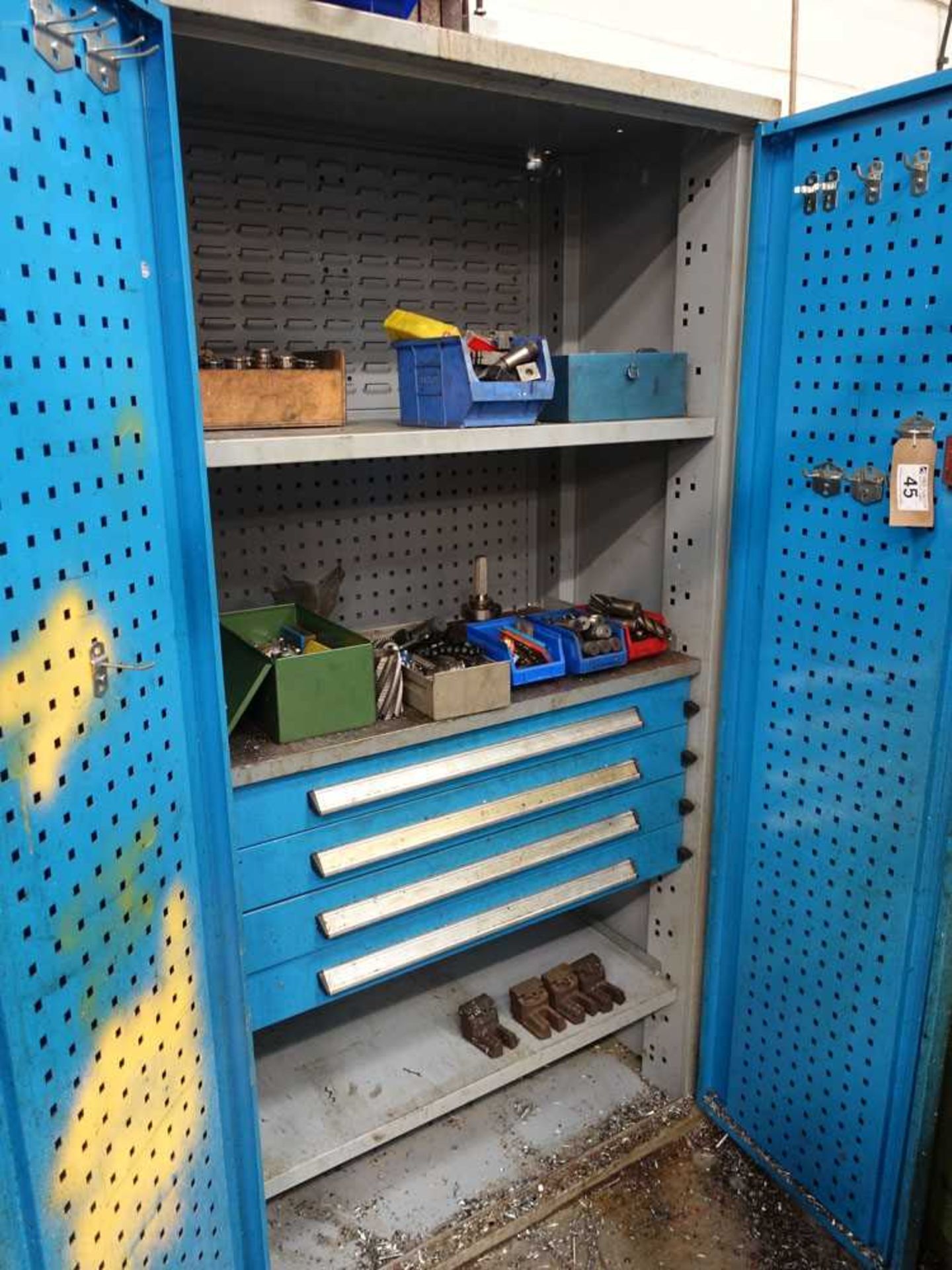 Blue steel double door machinists cabinet with 4 internal drawers containing a range of collets,