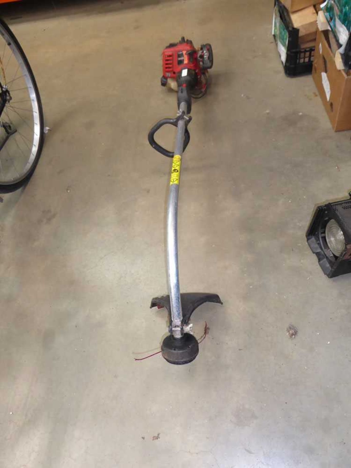 Red petrol powered bench shaft strimmer