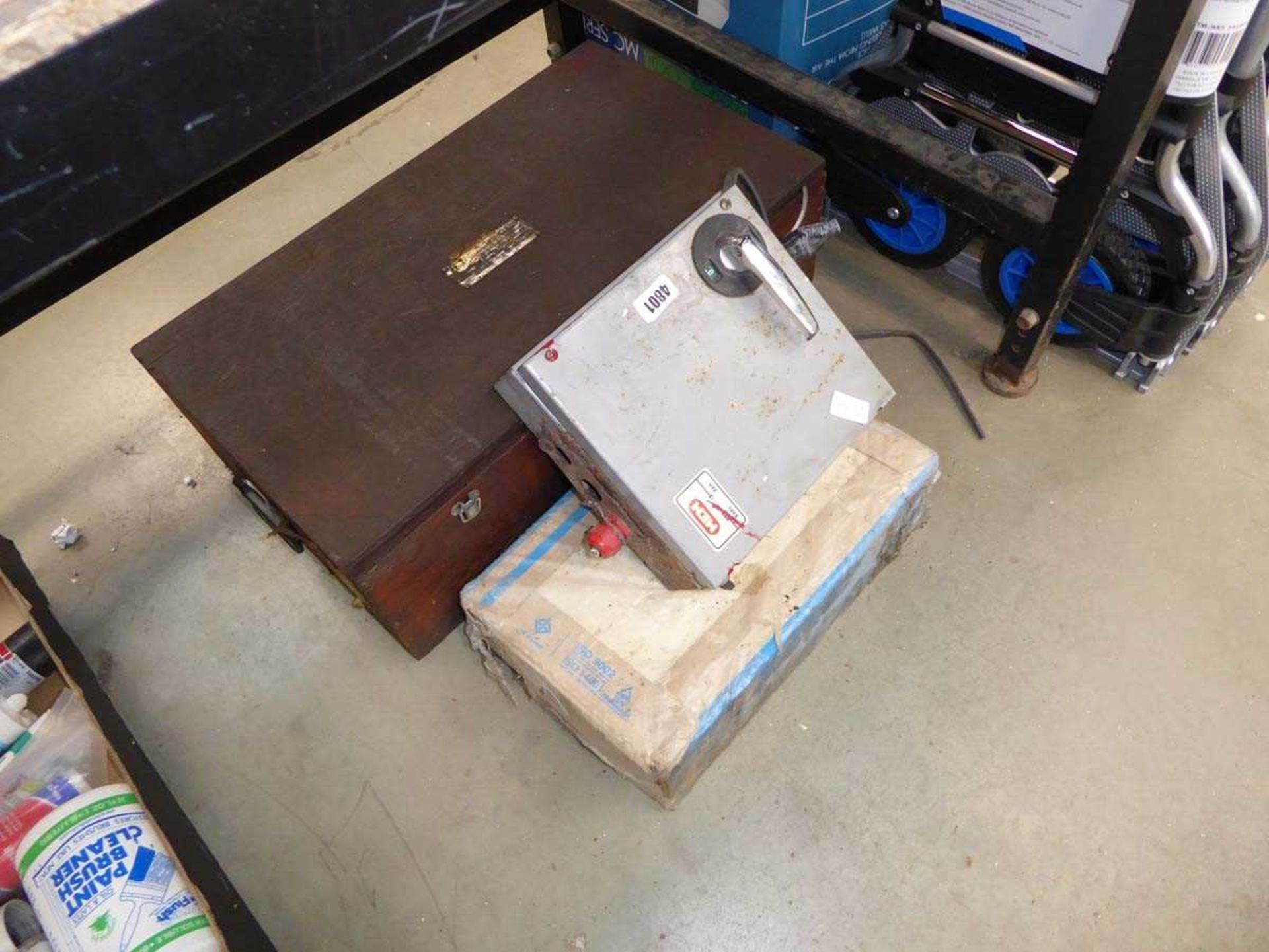 Wooden toolbox containing wire rope, junction box and pack of tiles