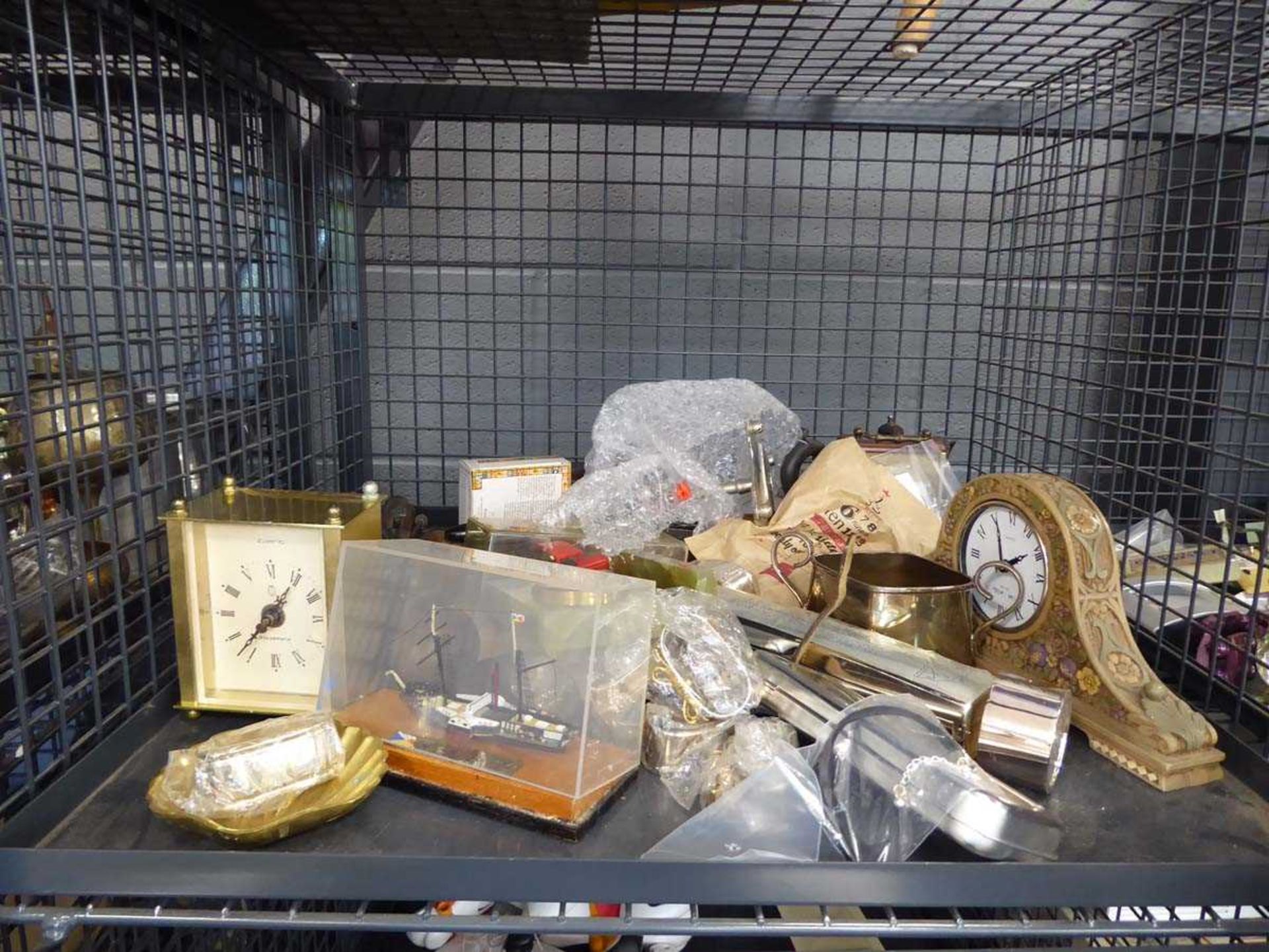 +VAT Cage containing quart clocks, silver plated napkin rings, tea service and ornamental boat