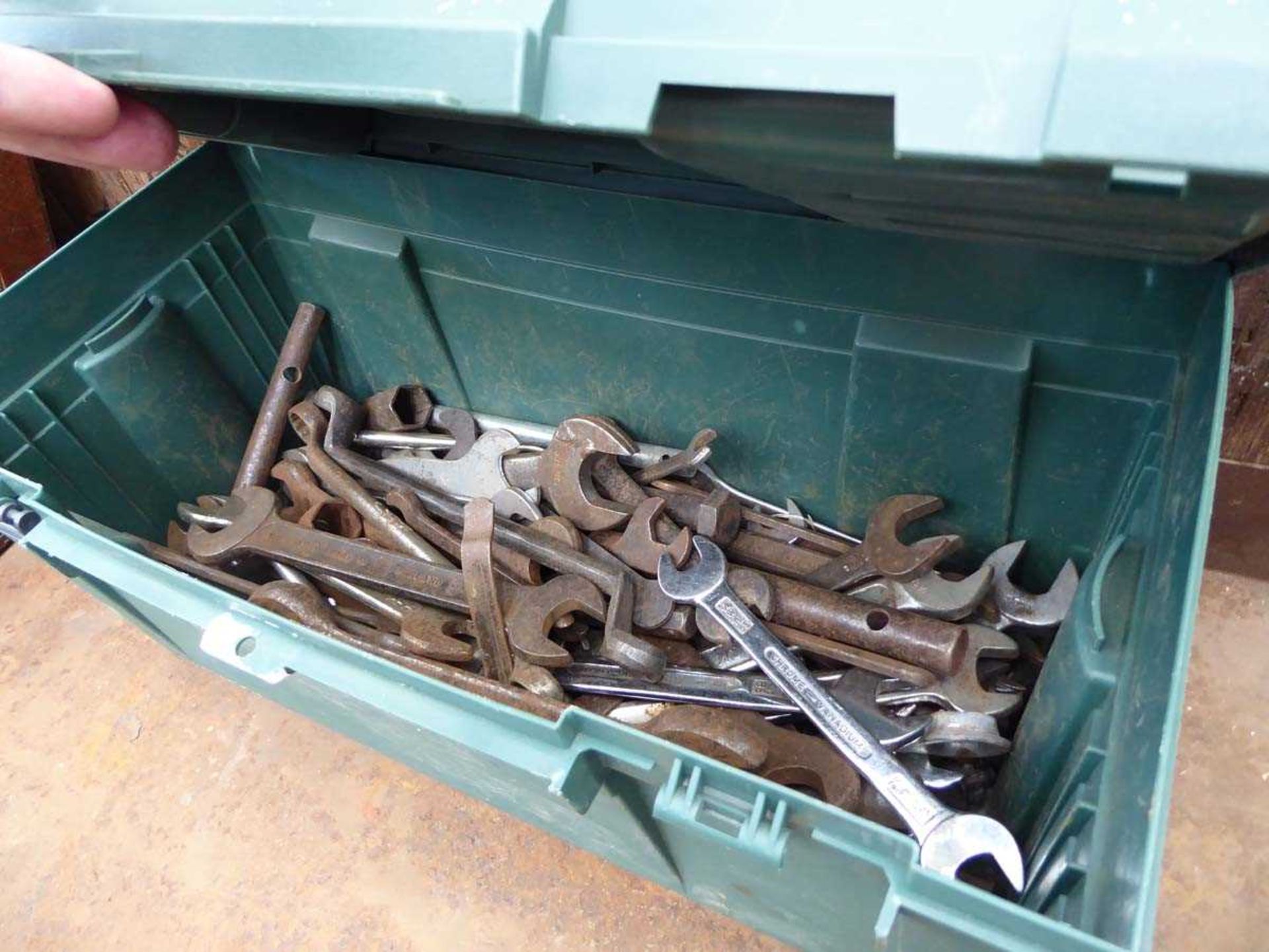 Green plastic tool box with various spanners