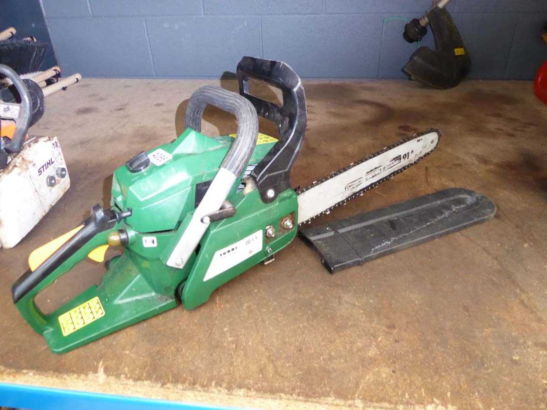 Green petrol powered chainsaw