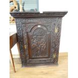 Heavily carved dark oak single door wall cabinet with Latin inscription 'Declining' the Crown