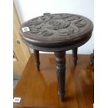 Small wooden circular stool with carved surface