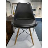 Single black plastic and vinyl upholstered Eames style dining chair