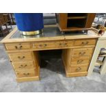 Modern pine twin pedestal desk with arrangement of 9 drawers and green leather writing surface