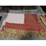 Red and pink natural fiber tasseled rug