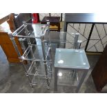 Three pieces of glass furniture including a three tier side table, a four tier stand and a frosted