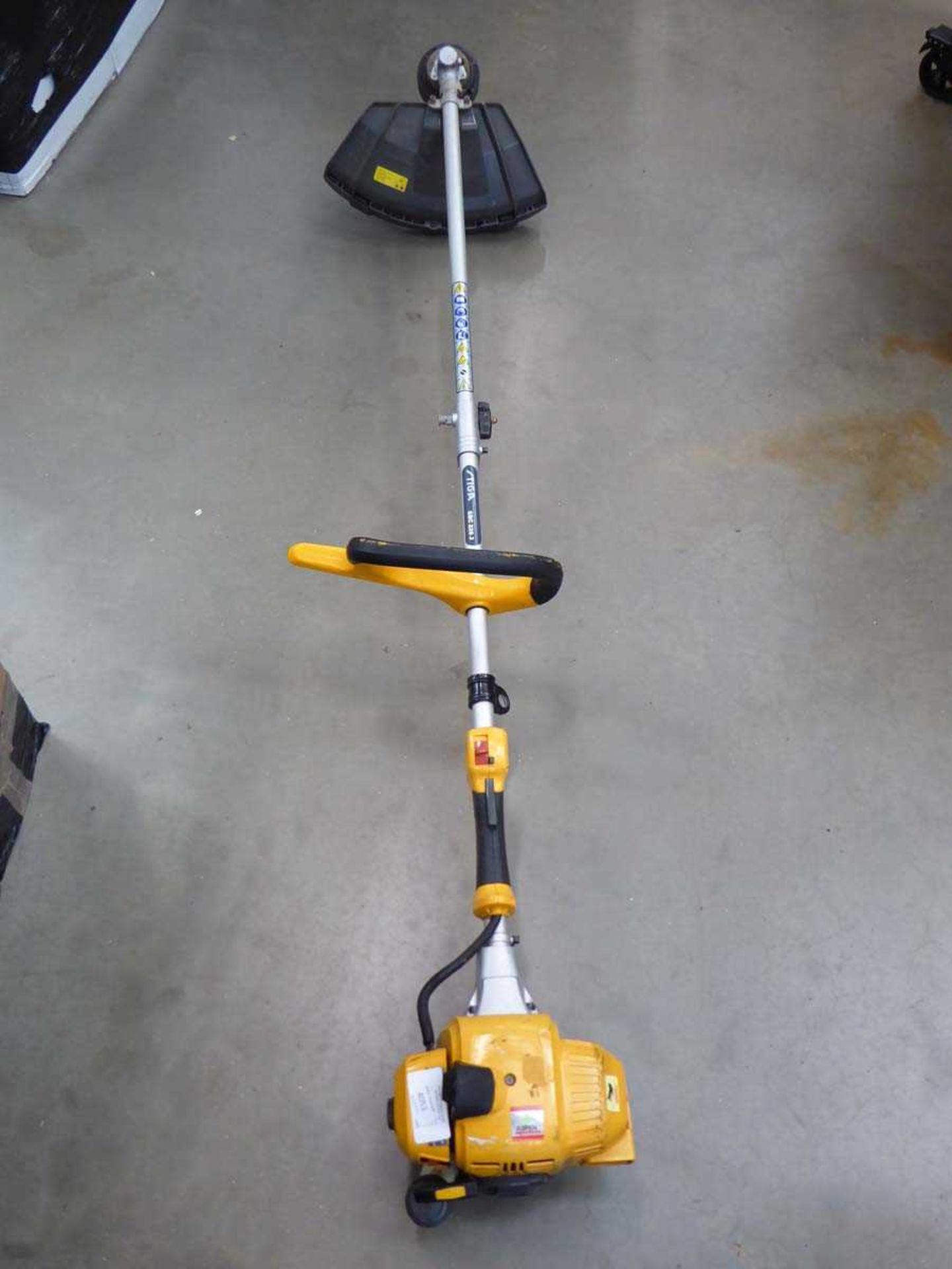 Yellow petrol powered strimmer