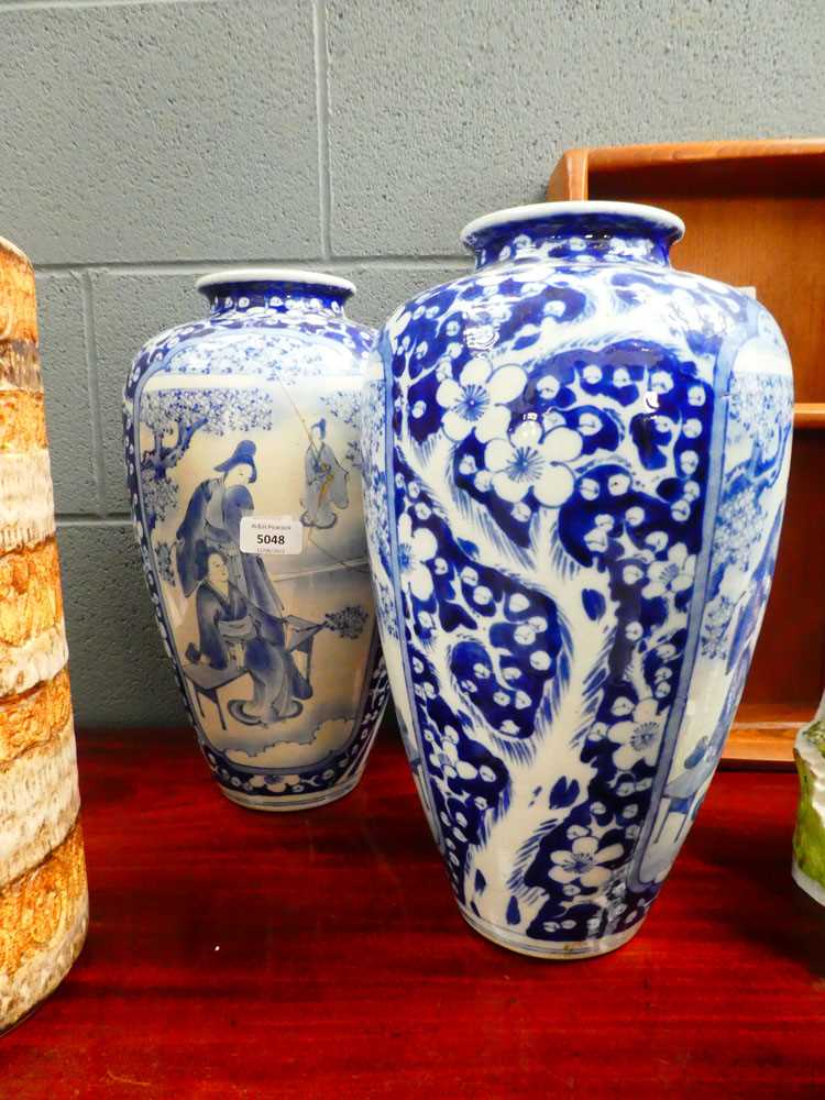 A pair of Chinese blue and white shouldered vases, each decorated with traditional figures at