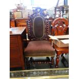 Heavily carved oak chair with upholstered seat and back rest